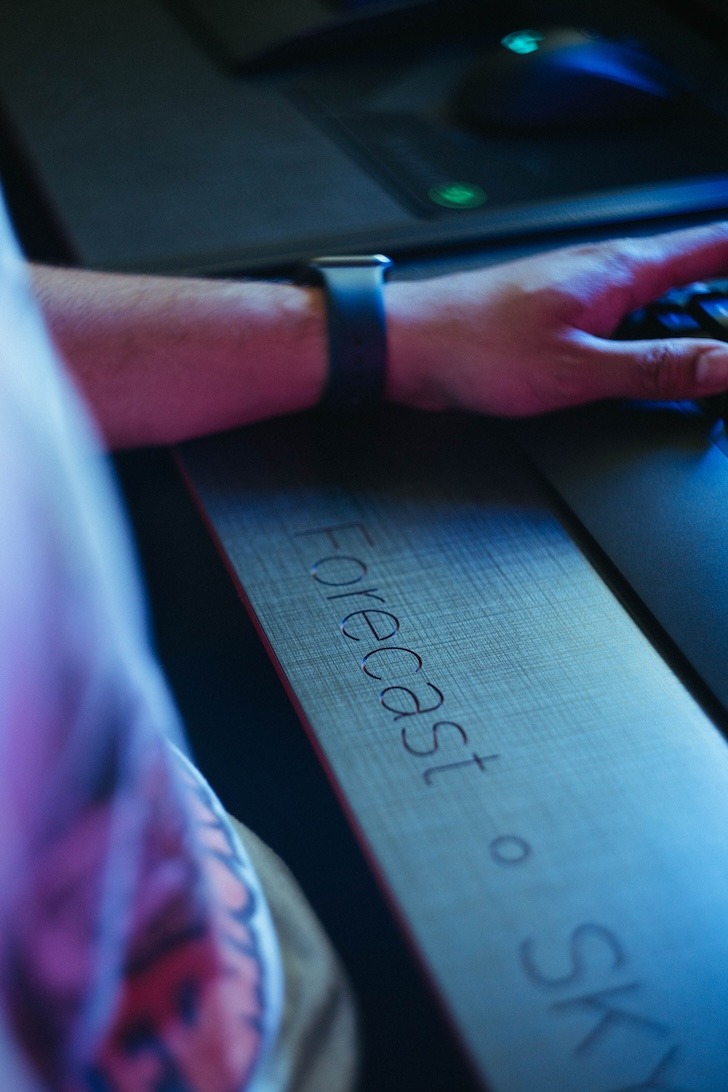 User sitting at a desk with forecast engraving